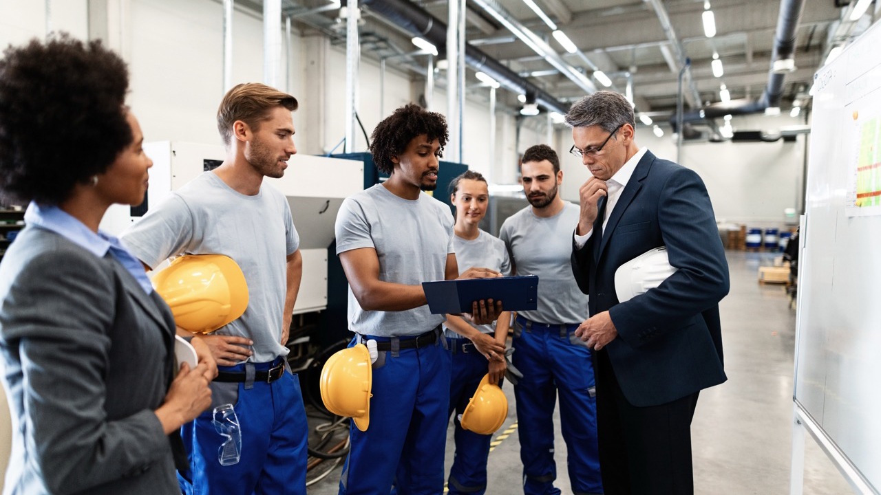 Company manager and African American worker cooperating while analzying production plans on a meeting in a factory.